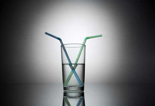 social distancing glass of water half full with 2  plastic drinking straws