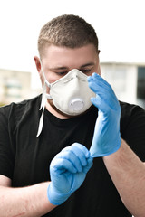 COVID-19 medicine, a man in a respirator and medical blue gloves