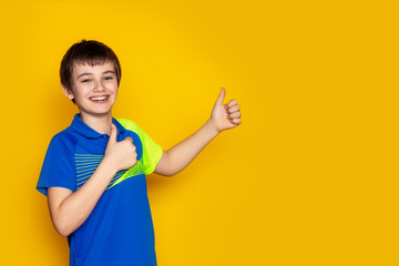 Baby girl teenager 11-12 years old in a sports uniform on a yellow background.