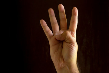 Man hand on black background. Gesture language with the hands. Non-verbal communication concept.