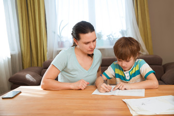 Mom helps child boy do lessons at home.  kid study at home.  quarantine. Corona Virus. 
