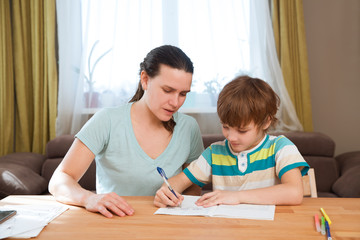 Mom helps child boy do lessons at home.  kid study at home.  quarantine. Corona Virus. 