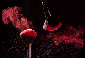 Colorful explosion on makeup brushes on a black background