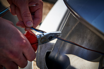 man cutting wire on a taillight