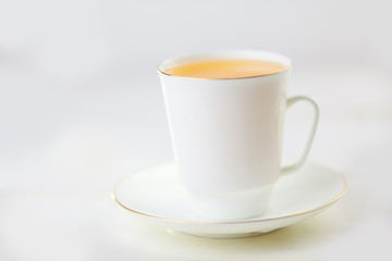 porcelainl cup with green tea on table