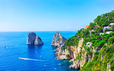 Ships near Faraglioni cliffs and Tyrrhenian Sea on Capri Island reflex