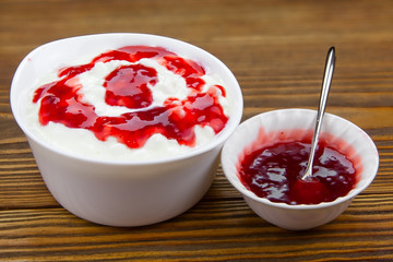 Tasty fresh grained cottage cheese on a plate on  wooden table