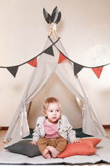 Cute little boy playing in a teepee