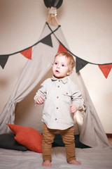 Cute little boy playing in a teepee