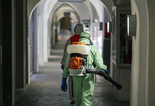 Sanitization, Cleaning And Disinfection Of The Streets And Alleys In The City Center Due To The Emergence Of The Covid-19 Virus. Specialized Team With Protective Suits And Masks At Work In The City.