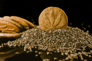 Medical Cannabis Seeds and CBD Cannabis Cookies on the black mirroring background.