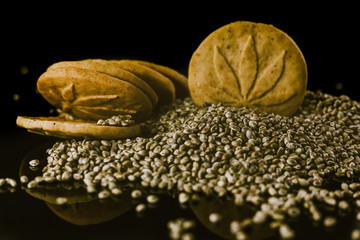 Medical Cannabis Seeds and CBD Cannabis Cookies on the black mirroring background.