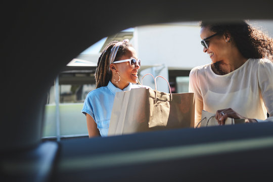 Women loading shopping bags into car