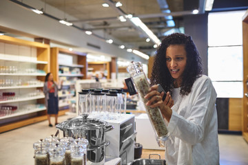 Woman shopping for pepper grinder in home goods store