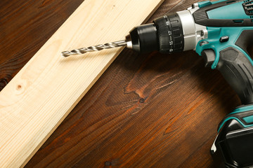 cordless drill on wooden background top view with copy space