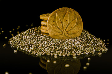 Medical Cannabis Seeds and CBD Cannabis Cookies on the black mirroring background.