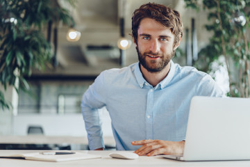 Businessman in shirt working on his laptop in an office. Open space office