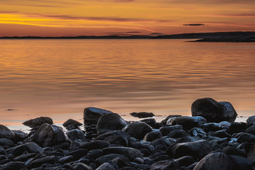 Złota godzina nad skalistym wybrzeżem podczas zachodu słońca w Parku Narodowym Ytre Hvaler w Norwegii - obrazy, fototapety, plakaty
