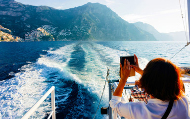 Tourist taking photos during cruise in Tyrrhenian Sea in Positano reflex