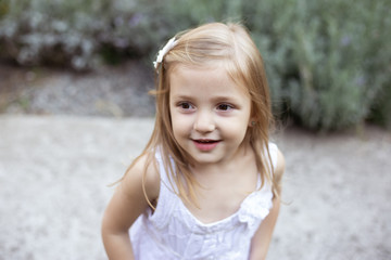 portrait of cute girl playing in sunny blooming garden