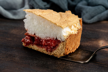 A piece of cake with a layer of beige and berry jelly
