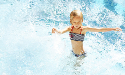 Fototapeta na wymiar Little girl having fun time in the Swimming pool