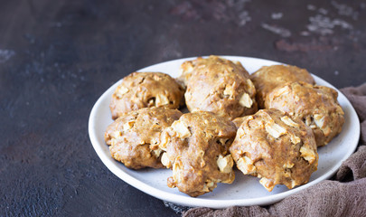Soft and tender apple biscuits on a ceramic plate, dark concrete background. Dessert or breakfast for children, sweet snack. Selective focus.