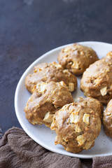 Soft and tender apple biscuits on a ceramic plate, dark concrete background. Dessert or breakfast for children, sweet snack. Selective focus.