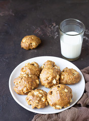 Homemade soft apple cookies on a plate with milk, dark concrete background. Dessert or breakfast for children, sweet snack. Selective focus.