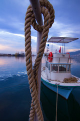 Obraz premium cute fishing boat and rope in the harbor