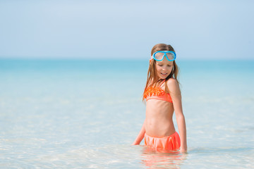 Adorable little girl have fun at tropical beach during vacation