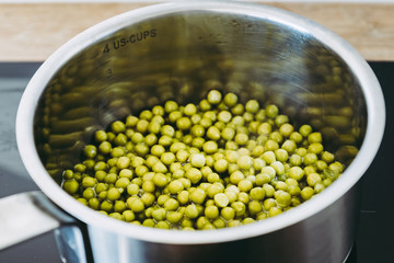 Petits pois verts en train de cuire dans une casserole