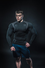Obraz na płótnie Canvas Sexy young athlete posing on a black background in the Studio. Fitness, bodybuilding
