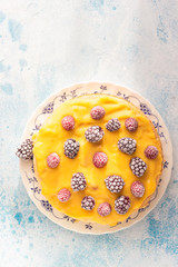 Angel food cake with lemon curd and frozen berries (raspberry and blackberry) on a plate, blue...