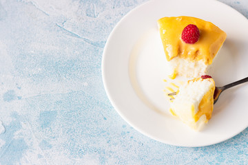 Slice of angel food cake with lemon curd and frozen berries (raspberry and blackberry), blue concrete background. 