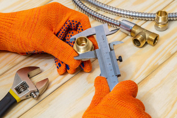 The wizard measures the size of fitting using a caliper before connecting water or gas pipe
