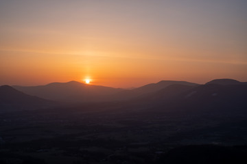 Fototapeta na wymiar sunrise sun in the mountains with fog