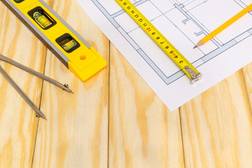 Accessories and drawing tools lie on a building project or wooden boards