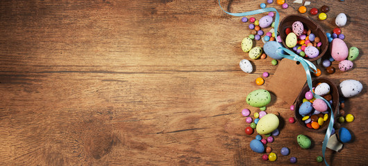 Colorful Easter candies on a rustic wood background