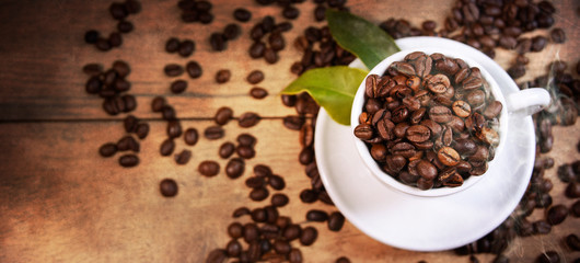 Coffee cup and beans on old kitchen table.