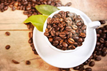 Coffee cup and beans on old kitchen table.