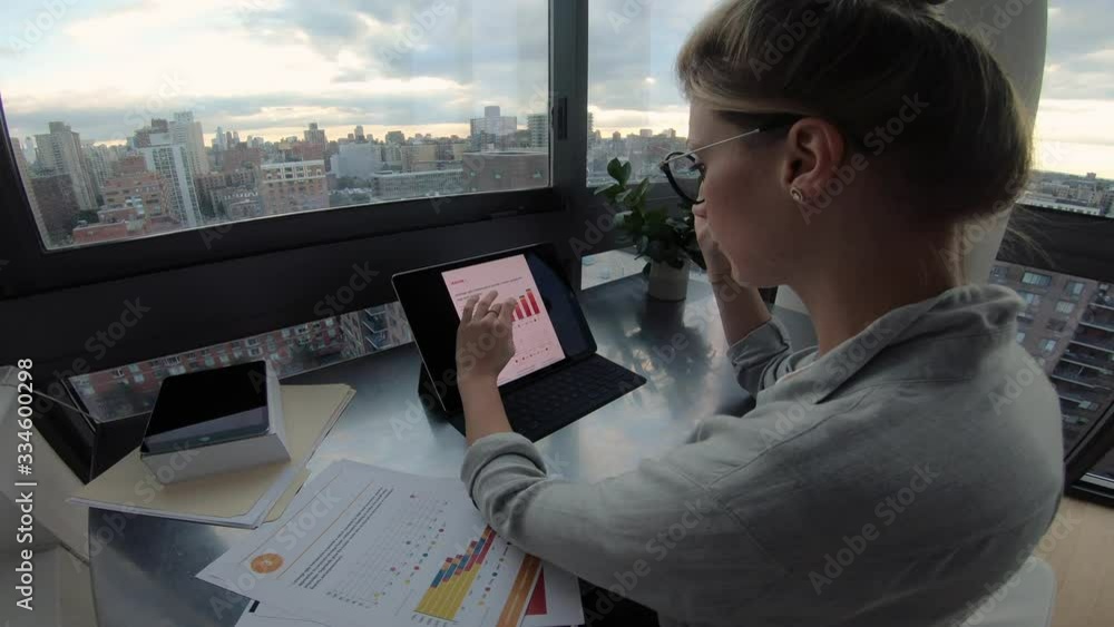 Poster zoom out of smart casual female economist working with statistic graphs on modern digital tablet usi