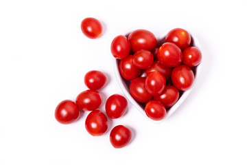 Cherry tomatoes in a heart-shaped bowl isolated on a white background.