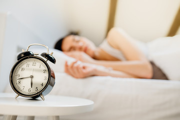 Alarm clock ringing.Woman waking up in early morning for work.Obstructive sleep apnea...