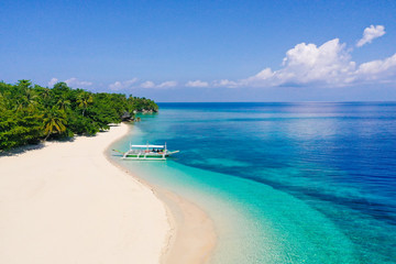 Fototapeta na wymiar Seascape with a beautiful tropical island, aerial view. Beautiful white sand beach. Mahaba Island, Philippines. Blue sea with turquoise lagoons. Summer and travel vacation concept.
