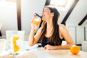Woman at home drinking orange flavored amino acid vitamin powder.Keto supplement.After exercise liquid meal.Weight loss fitness nutrition diet.Immune system support.Organic citrus fruit.Strong body - obrazy, fototapety, plakaty