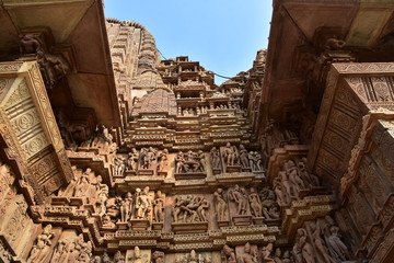 インドのカジュラーホー　世界遺産のカジュラーホー寺院　ヒンドゥー教の物語を表した繊細な彫刻　エロチックな天女像や男女交合像 - obrazy, fototapety, plakaty