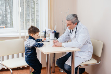 A young boy is listened to and treated by an experienced doctor in a modern clinic. A virus, and an epidemic