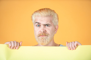 Portrait of funny man showing blank signboard with copyspace area for slogan or text. Blank, empty...