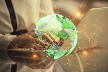 Double exposure of woman hands typing on computer and social network theme hologram drawing. People...